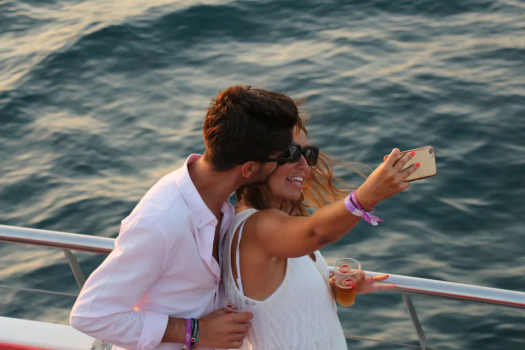 couple taking selfie at belize boat party by algarexperience