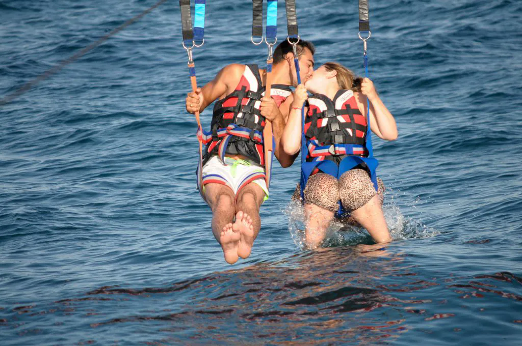 couple enjoy the sea parasailing water sports by algarexperience